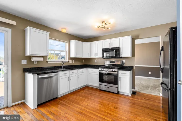 a kitchen with a refrigerator a stove top oven a sink and dishwasher