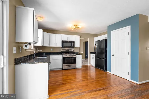 a kitchen with granite countertop wooden floors and wide window