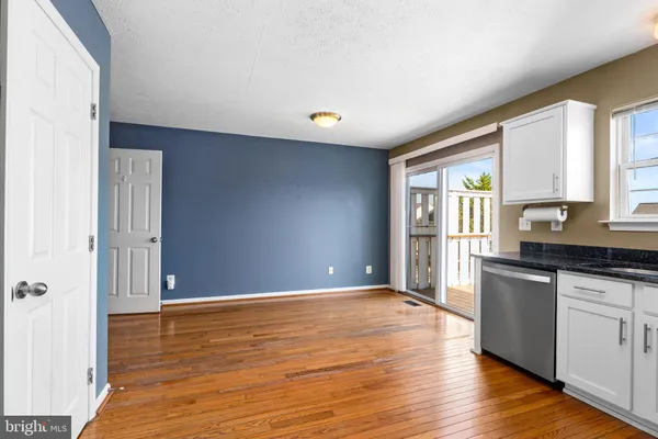 a kitchen with granite countertop a stove a sink and wooden floor