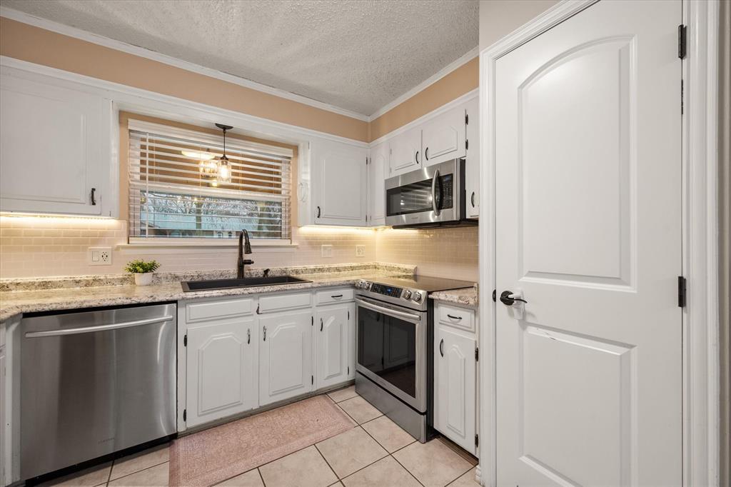 806 Ridgeway Road Joshua, TX 76058 - Photo 12 of 27 a kitchen with stainless steel appliances granite countertop a sink stove and refrigerator
