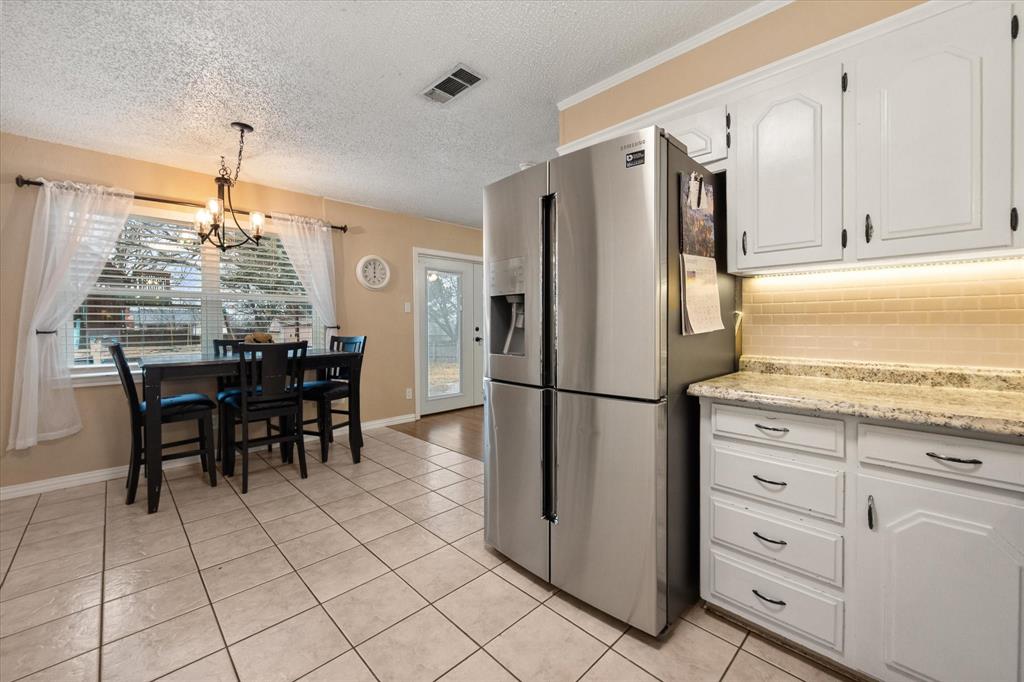 806 Ridgeway Road Joshua, TX 76058 - Photo 13 of 27 a kitchen with refrigerator cabinets and dining table