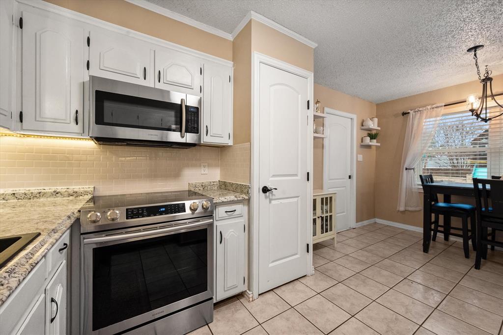 806 Ridgeway Road Joshua, TX 76058 - Photo 14 of 27 a kitchen with stainless steel appliances a stove a microwave and cabinets