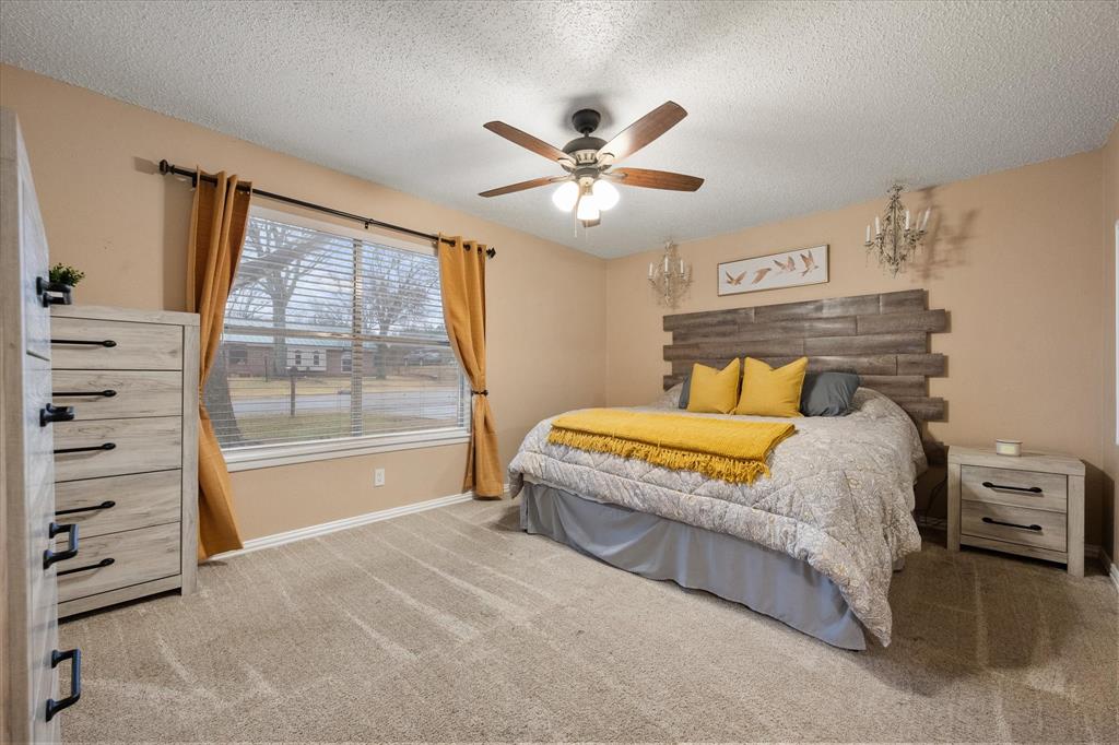 806 Ridgeway Road Joshua, TX 76058 - Photo 16 of 27 a bedroom with a large bed and a chandelier
