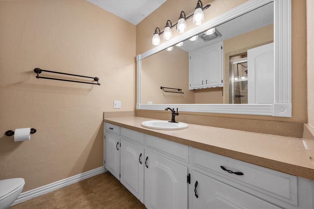 806 Ridgeway Road Joshua, TX 76058 - Photo 18 of 27 a bathroom with a sink a toilet and a mirror