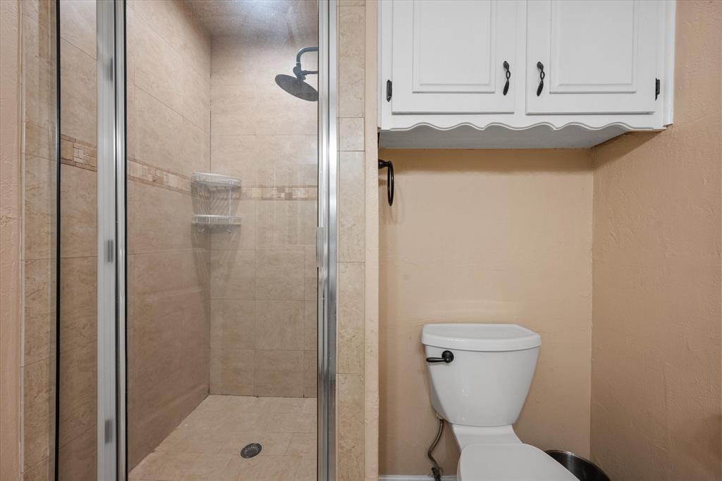 806 Ridgeway Road Joshua, TX 76058 - Photo 19 of 27 a bathroom with a granite countertop toilet a sink and shower
