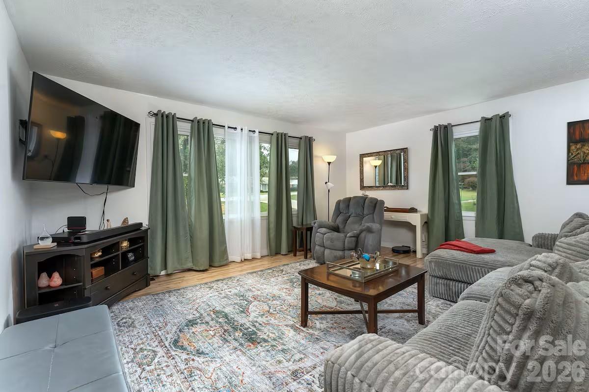 124 Oak Hill Road Candler, NC 28715 - Photo 11 of 29 a living room with furniture a flat screen tv and a window