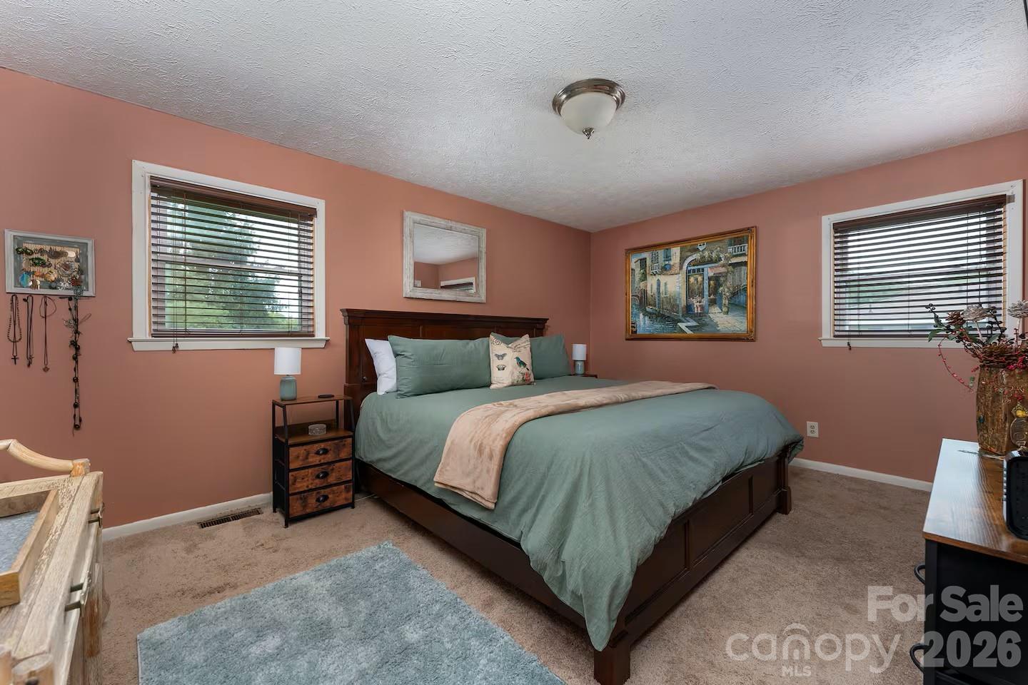 124 Oak Hill Road Candler, NC 28715 - Photo 12 of 29 a bedroom with a bed and a dresser next to a window