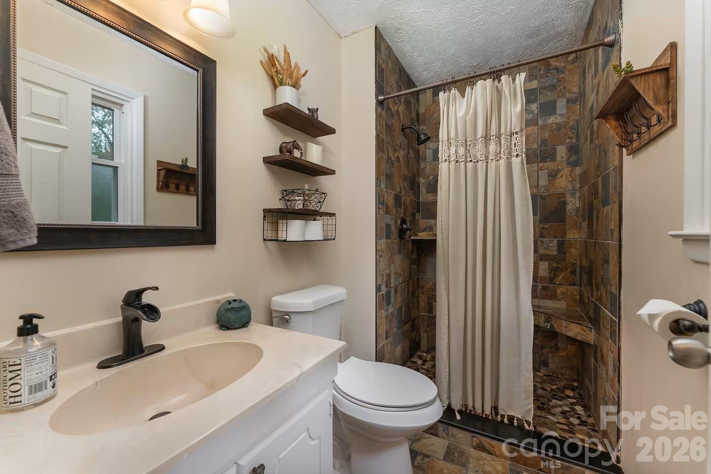 124 Oak Hill Road Candler, NC 28715 - Photo 13 of 29 a bathroom with a sink toilet and shower