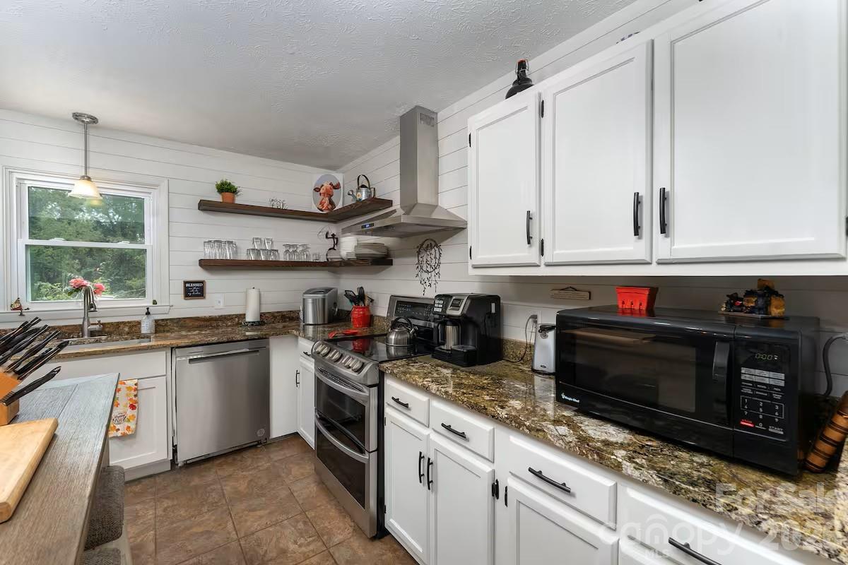 124 Oak Hill Road Candler, NC 28715 - Photo 6 of 29 a kitchen with stainless steel appliances granite countertop a stove and a sink