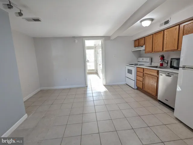 a kitchen with a stove a sink and cabinets
