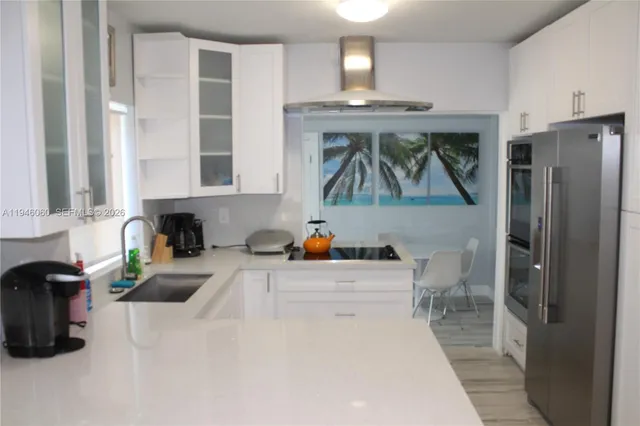 a kitchen with stainless steel appliances granite countertop a sink and a refrigerator