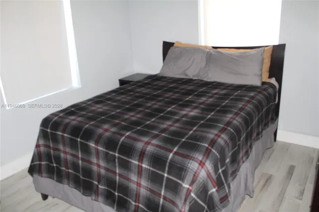 a bed sitting in a bedroom next to a window