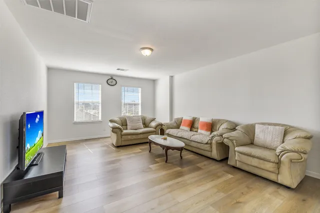a living room with furniture and a wooden floor