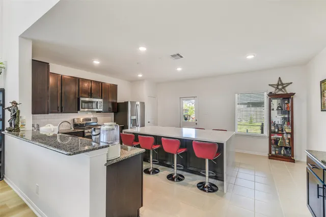 a kitchen that has a lot of cabinets and refrigerator in it