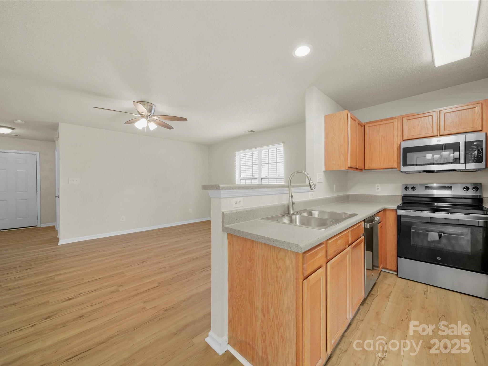 6420 Sunman Road Charlotte, NC 28216 - Photo 25 of 43 a kitchen with stainless steel appliances granite countertop a sink stove and refrigerator
