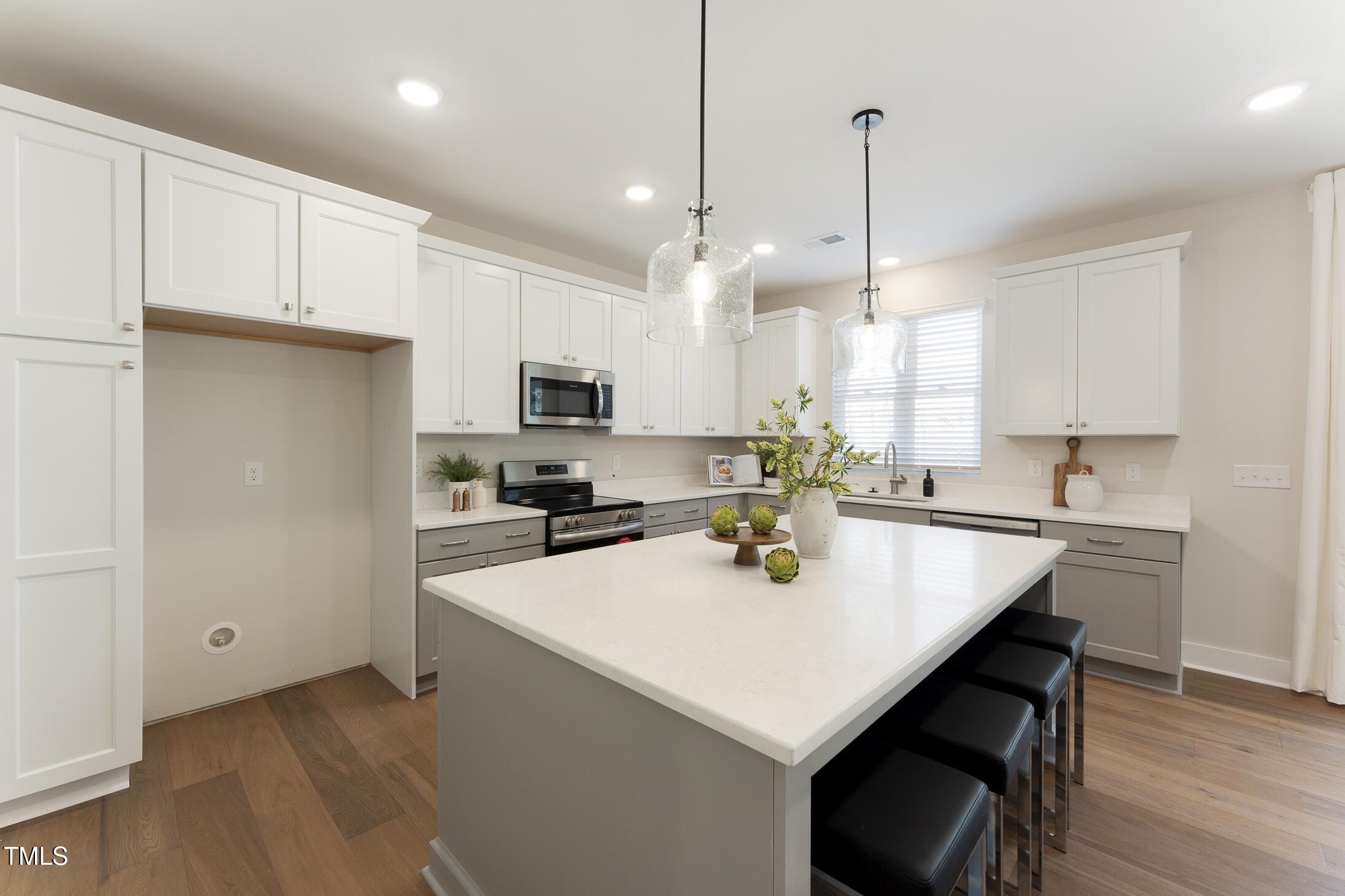 604 Whistable Avenue Wake Forest, NC 27587 - Photo 11 of 44 a kitchen with a sink a stove a refrigerator and white cabinets