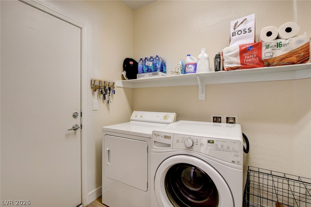2649 Rue Marquette Avenue Henderson, NV 89044 - Photo 40 of 55 Functional laundry space featuring a full-size washer and dryer, complemented by a convenient wall shelf for storage.