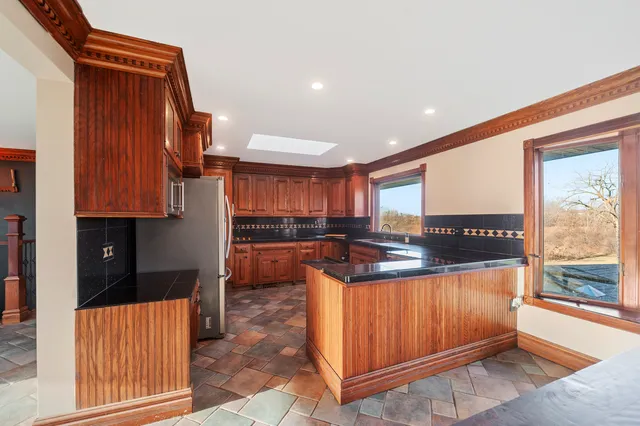 a kitchen with stainless steel appliances kitchen island granite countertop a refrigerator and a stove