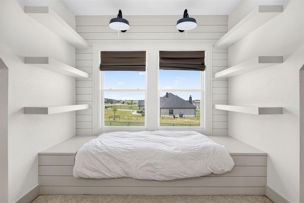 3008 Perkins Weatherford, TX 76088 - Photo 29 of 36 Built-in window bed with shiplap detailing, dual sconce lighting, two windows with Roman shades, and six floating wall shelves