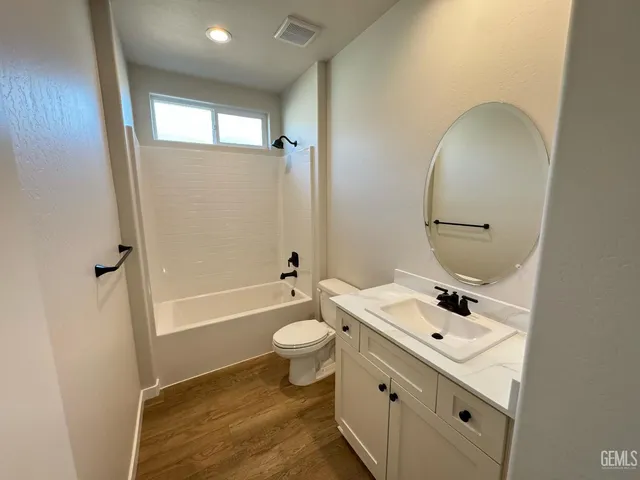 a bathroom with a sink mirror toilet and bathtub