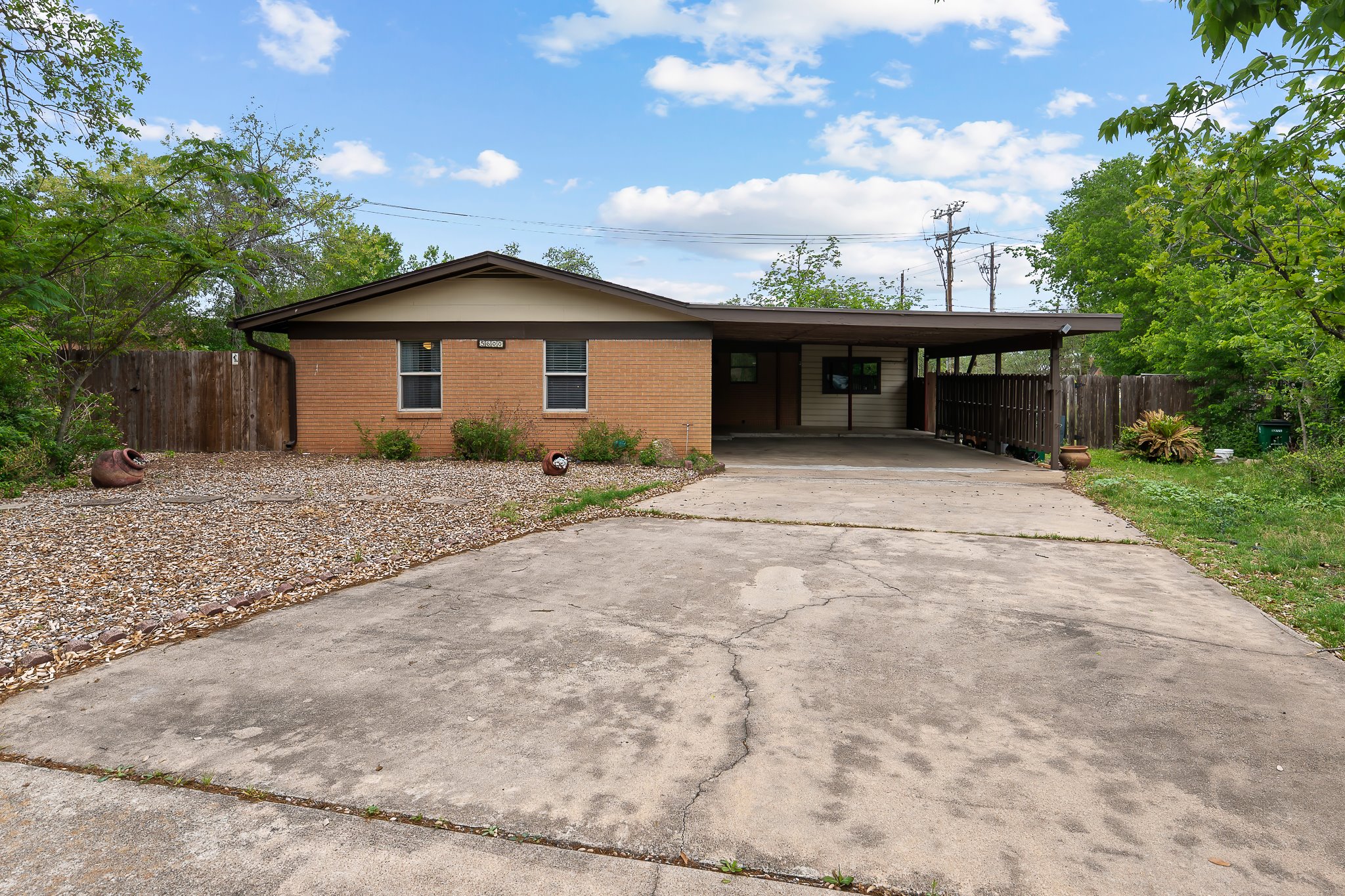 5600 Libyan Circle Austin, TX 78745 - Photo 1 of 37 Ranch-style home featuring a carport, concrete driveway, and brick siding