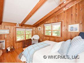 1348 Saunook Road Waynesville, NC 28786 - Photo 7 of 24 a bedroom with a bed and wooden floor