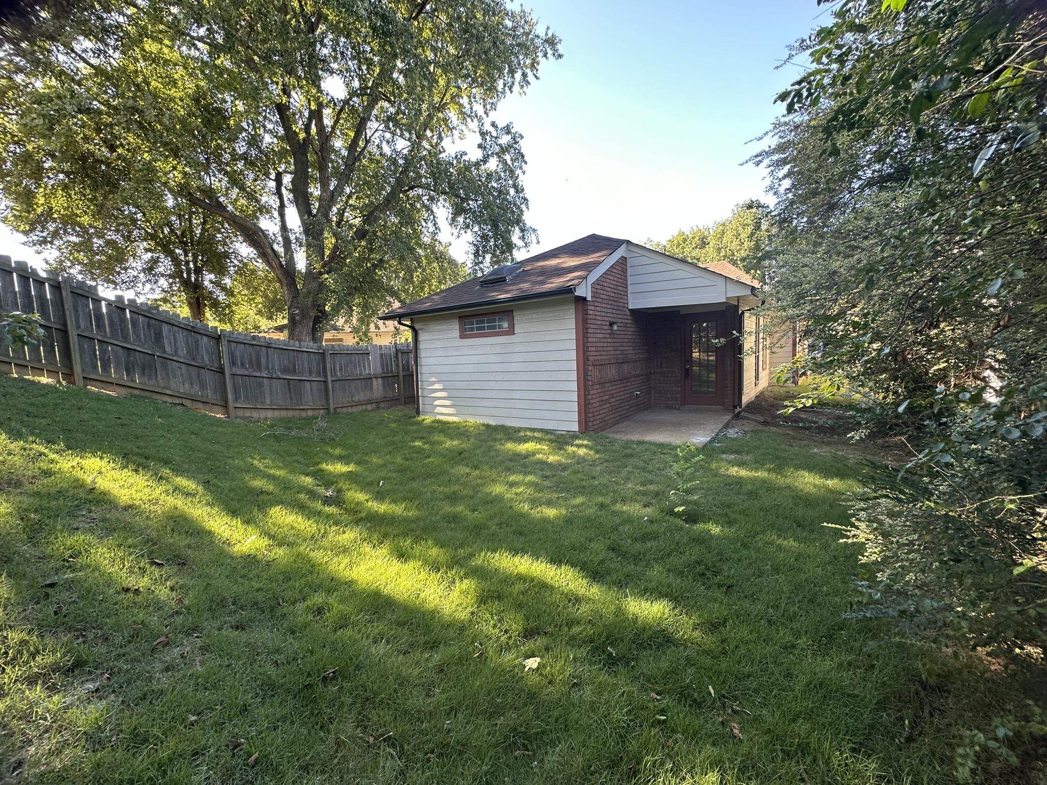 5435 Pine Oak Lane Bartlett, TN 38135 - Photo 14 of 17 a backyard of a house with plants and large tree