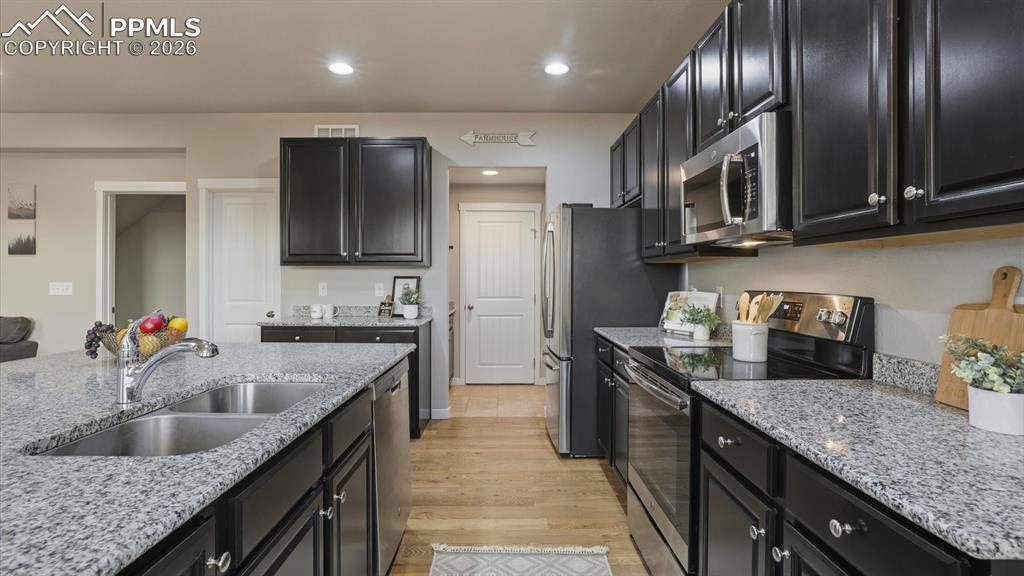 7872 Callendale Drive Colorado Springs, CO 80908 - Photo 18 of 50 Stainless steel appliances include a smooth top range oven, microwave, dishwasher, and French door refirgerator.