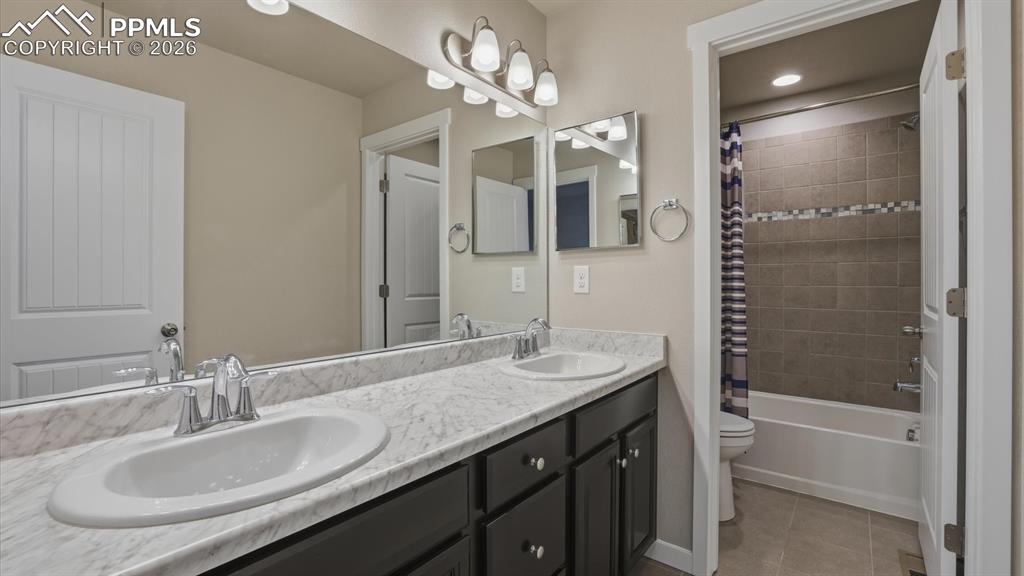 7872 Callendale Drive Colorado Springs, CO 80908 - Photo 34 of 50 Upper Level Hall Bathroom with a dual sink vanity mirror, and tiled tub/shower.