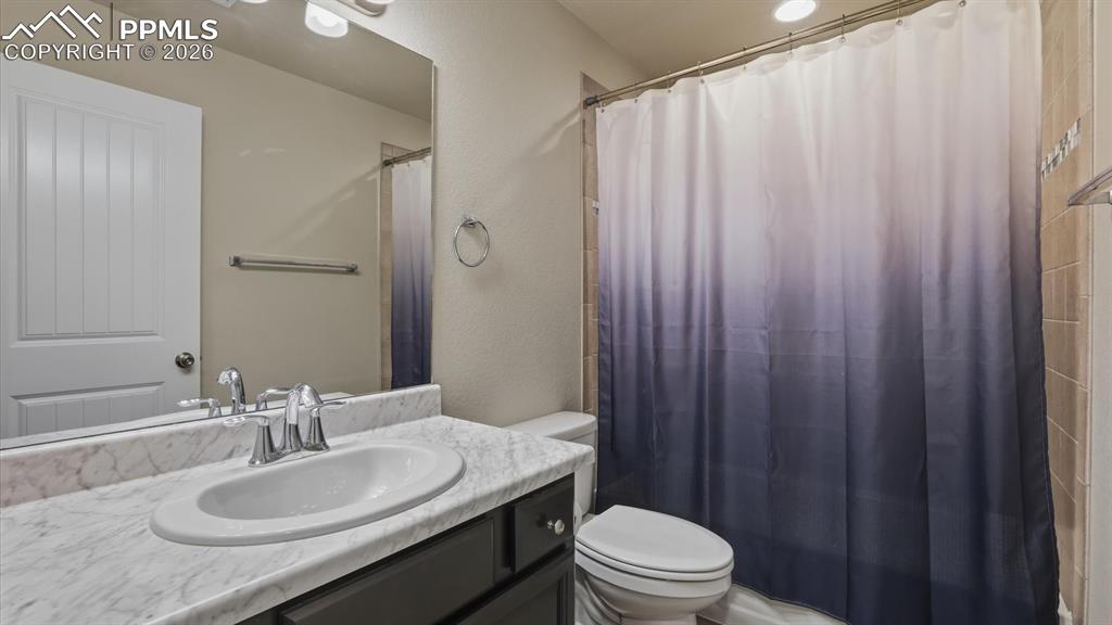 7872 Callendale Drive Colorado Springs, CO 80908 - Photo 44 of 50 Basement Full Bathroom with vanity, mirror, and tiled tub/shower.