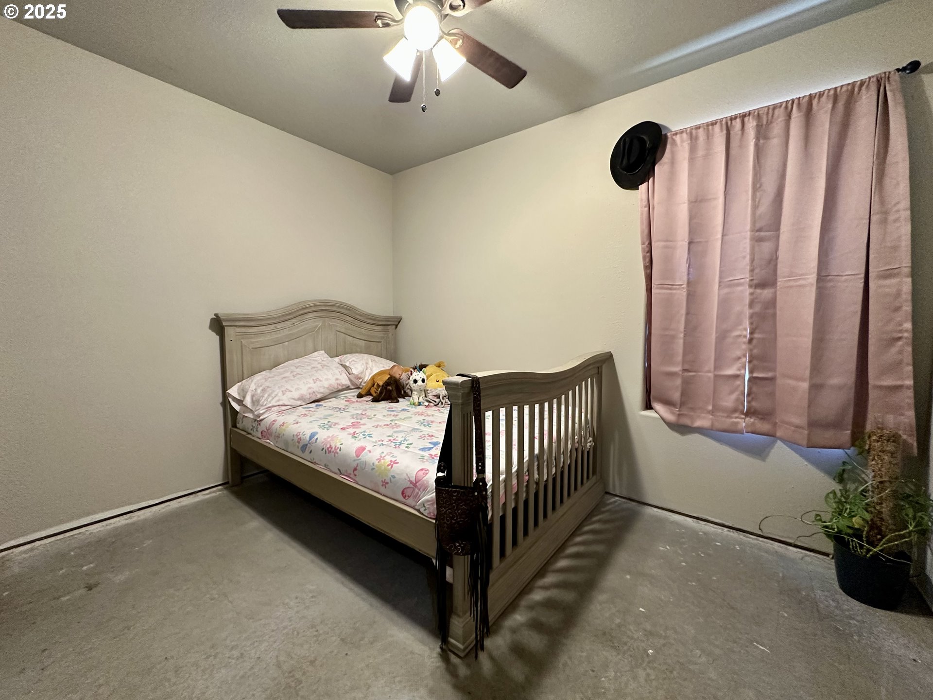 416 4th Street Summerville, OR 97876 - Photo 15 of 40 a bed sitting in a bedroom next to a window and a chandelier