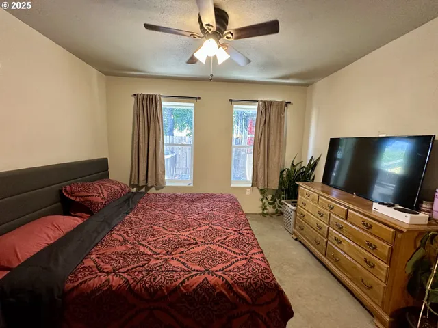 a bedroom with bed and flat screen tv