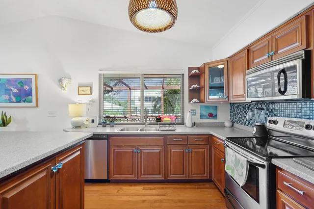 a kitchen with stainless steel appliances granite countertop a sink and wooden cabinets