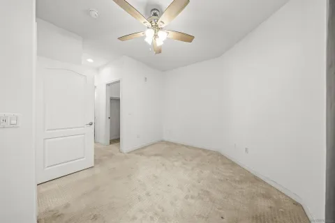 an empty room with a ceiling fan and a window
