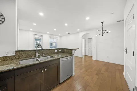a kitchen with stainless steel appliances granite countertop a sink and a refrigerator