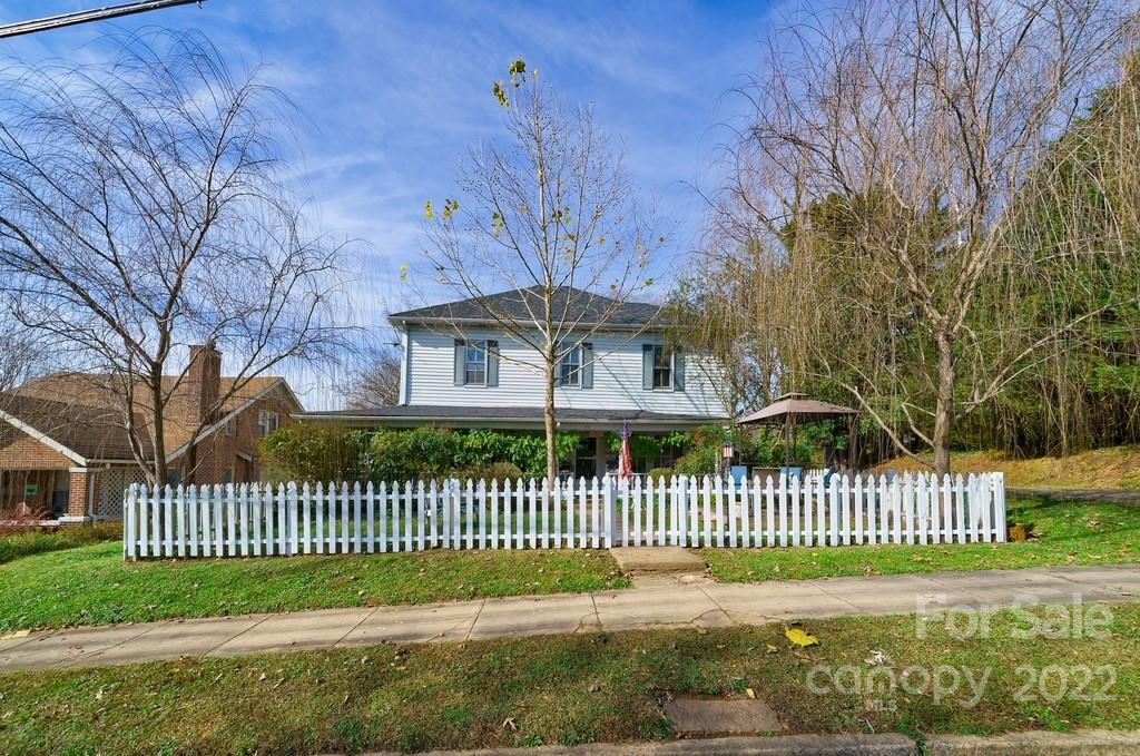 a front view of a house with a garden and tree