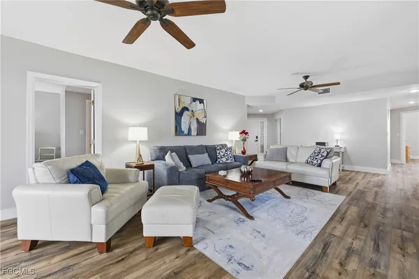 a living room with furniture and a wooden floor