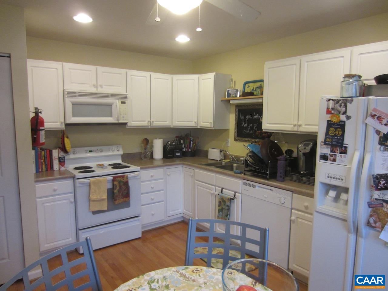 1420 Lilac Court Charlottesville, VA 22901 - Photo 4 of 15 a kitchen with stainless steel appliances granite countertop a stove top oven a sink a refrigerator a dining table and chairs with wooden floor