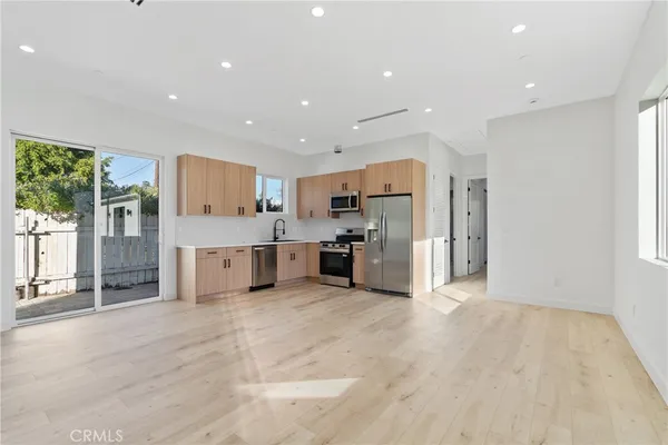 a large white kitchen with stainless steel appliances granite countertop a large counter top and a floors