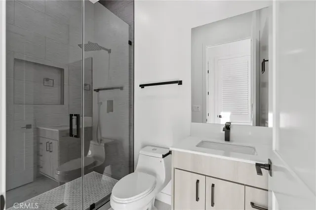 a bathroom with a sink toilet vanity and shower