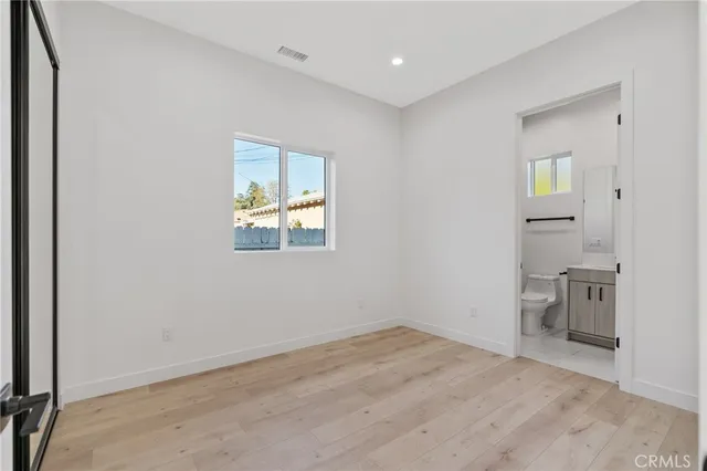 an empty room with a bathroom and a window