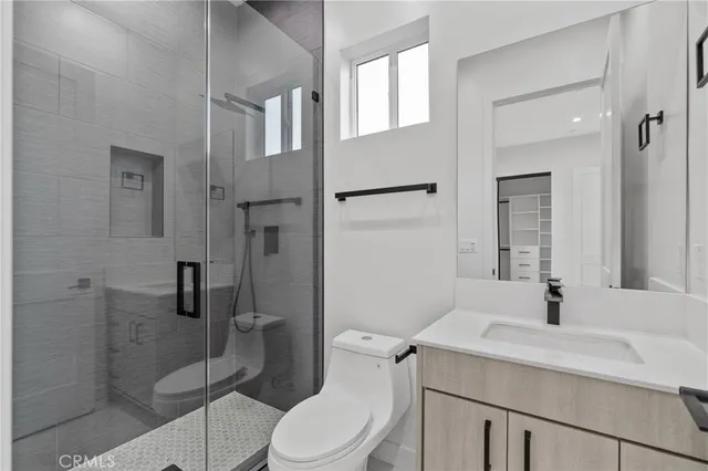 a bathroom with a sink toilet vanity and shower