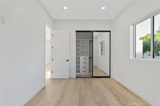 an empty room with windows and closet