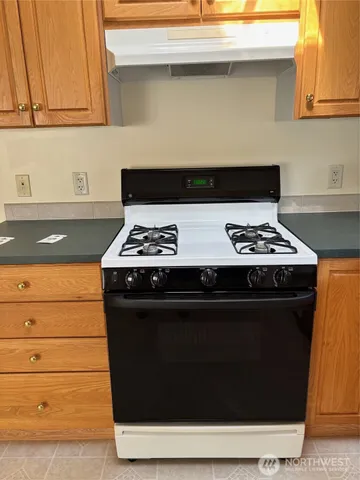 a kitchen with granite countertop a refrigerator and a sink