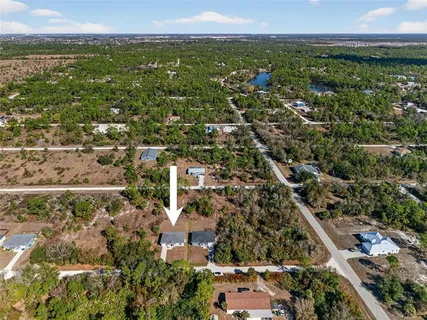 an aerial view of residential houses with outdoor space and trees