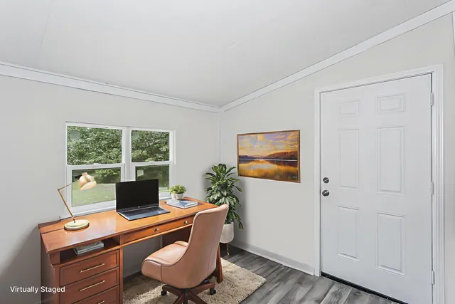 a view of a workspace with furniture and a window