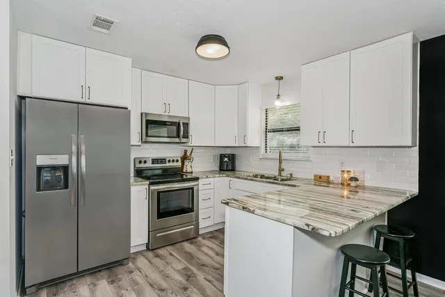 a kitchen with stainless steel appliances granite countertop a stove refrigerator sink and cabinets