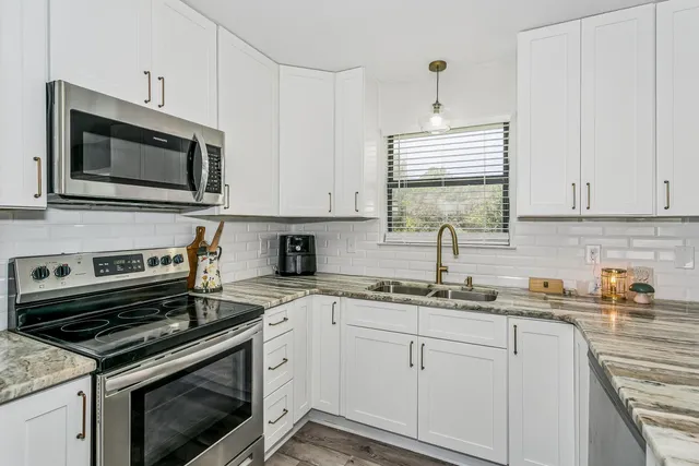 a kitchen with cabinets stainless steel appliances and a sink