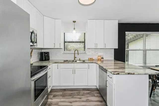 a kitchen with stainless steel appliances granite countertop a stove sink and cabinets