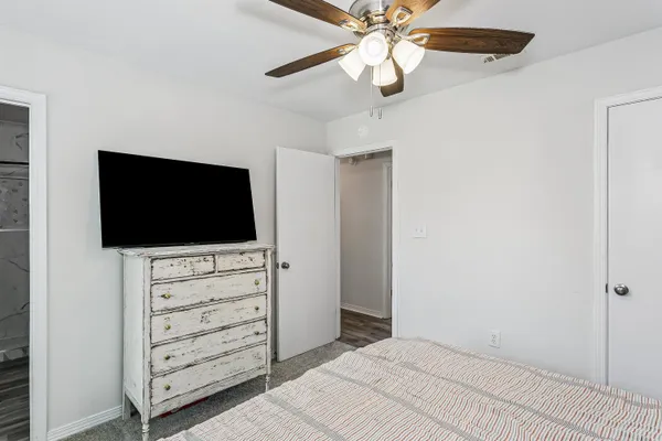 a view of bedroom with wooden floor and flat screen tv